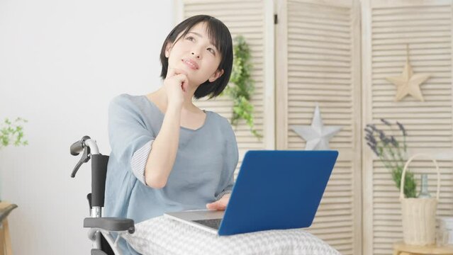 車椅子でノートパソコンを使う若い女性　多様性社会イメージ