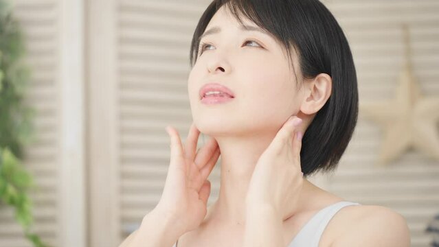 耳下腺のセルフマッサージをする若い女性　美容イメージ	
