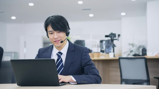 ヘッドセットで通話するビジネスマン　オペレーター　コールセンター