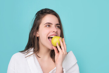 Woman with apples. Young woman eating apple over blue isolated background. Bitten apple with...
