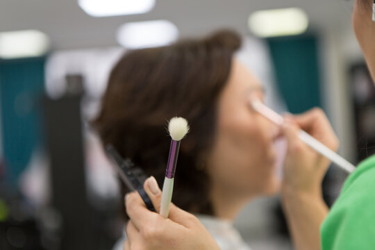 Makeup process, make-up artist paints model in salon