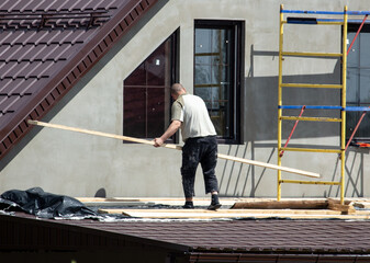 Workers are plastering the walls of the house outside. Cottage