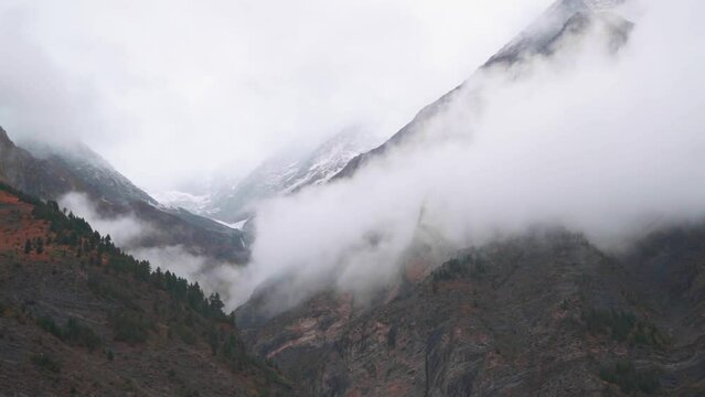 Fog around the mountain peaks during the stormy weather at Tandi in Lahaul Spiti district at Himachal Pradesh, India. Clouds rolling over the peaks of the mountain. Natural mountain background. 