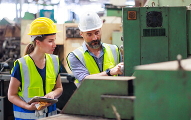 Training trainee concept. Hispanic latin male engineer explain the procedure for using the correct metal robot machine at lathe industrial factory.