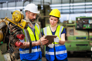 Training trainee concept. Hispanic latin male engineer explain the procedure for using the correct metal robot machine at lathe industrial factory.