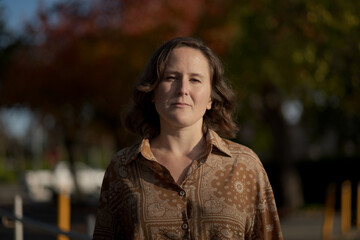 Fototapeta premium A nonbinary White person expresses themselves outdoors in a park setting.