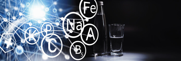 Obraz premium Close up pouring purified fresh drink water from the bottle on table in living room. Drinking water. Mineral vitamin water. Healthy, mineral-rich, refreshing water.