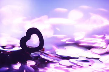 Love background. Red beads in the shape of a heart on a glitter and bokeh background.