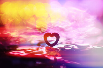 Abstract colored background. Red toy in the shape of a heart on a glitter and bokeh background.