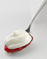 Yogurt on spoon,  strawberry, isolated on white background
