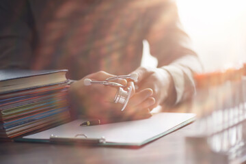 Male doctor search information in book and writtnig prescription, medical stethoscope on the desk at clinic. Medical knowledge and education concept.