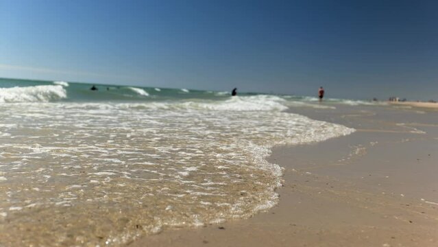 Small waves in shallow ocean roll onto calm
and clean beach shoreline Grange Beach South Australia