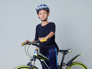 Little boy with bicycle on light background