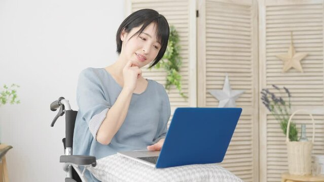 車椅子でノートパソコンを使う若い女性　多様性社会イメージ