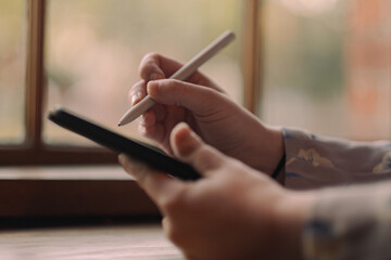 S. setting goals on a tablet while working at a café.