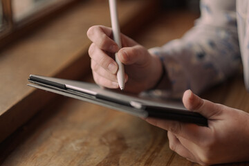 S. setting goals on a tablet while working at a café.
