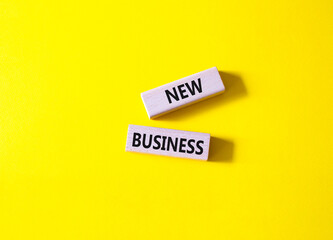 New business symbol. Concept words New business on wooden blocks. Beautiful yellow background. Business and New business concept. Copy space.