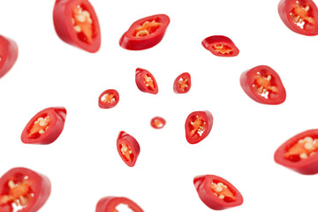 Falling sliced red hot chilli peppers isolated on white background, selective focus