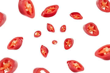 Poster Im Rahmen Falling sliced red hot chilli peppers isolated on white background, selective focus © grey