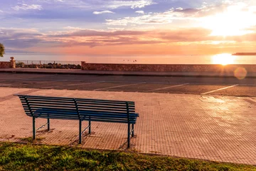 Peel and stick wall murals Destinations metallic bench on sea embarkment with asphalt road and beautiful seashore landscape with amazing cloudy sky