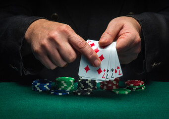 The player points with his finger at a winning four of a kind or quads combination in poker game on...