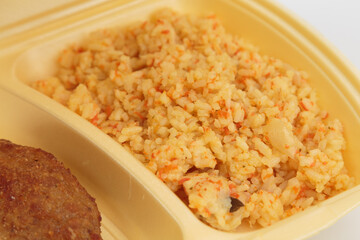 Cutlet and rice in a plastic box for delivery.