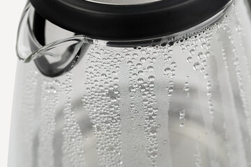 Electric glass teapot with water drops.