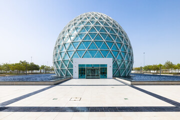 Symmetrical view of the modern-looking light blue spherical visitor center of the Sheik Zayed mosque at Abu Dhabi