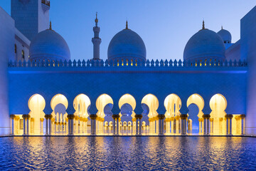 Sideview during the blue hour of the majestic Sheik Zayed mosque in Abu Dhabi reflected on the water