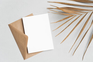 Invitation or greeting card mockup with palm tree leaf and envelope