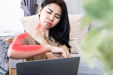 Asian woman suffering from neck pain spreading to shoulder and down arm caused by overworked on a...
