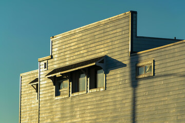 Urban building facade in sunset lighting with clear blue sky background in wild west style saloon or residence