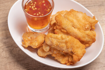 Fried chicken nuggets with dipping sauce in white plate