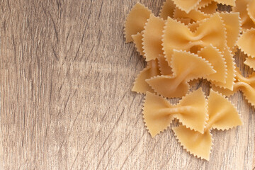 Raw macaroni on wooden background
