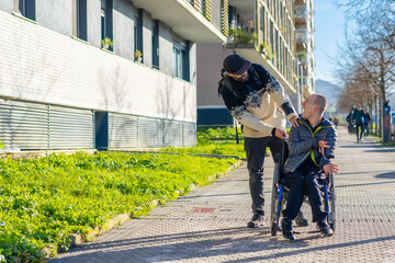 A disabled person walking with a friend in a wheelchair on the street
