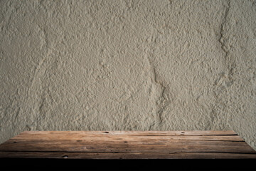 Empty wooden board on table top and blur inside over stucco wall blur background, mock up for display of goods.