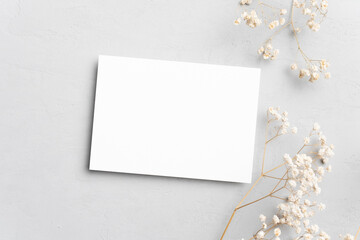 Blank invitation or greeting card mockup with flowers, wedding card flat lay