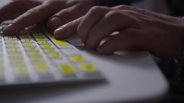 Close-up: A man uses a keyboard with braille.A blind man is typing words on the buttons with her hands. Technological device for visually impaired people. Tactilely touches bumps on the keys
