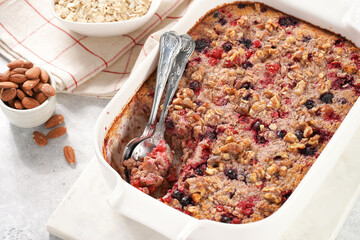 breakfast casserole idea - oven berry baked oatmeal with almonds, walnuts and coconut flakes in a...