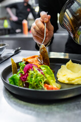 chef hand preparing Meat Pie with mashed potato and salad on restaurant kitchen