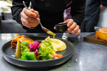 chef hand preparing Meat Pie with mashed potato and salad on restaurant kitchen