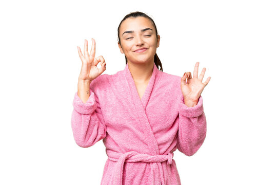 Young woman in a bathrobe over isolated chroma key background in zen pose
