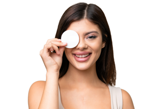 Young Russian woman with rainproof coat and umbrella over isolated chroma key background with cotton pad for removing makeup from her face and smiling