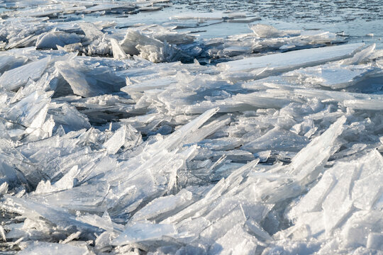 Broken sharp hummock ice floes in the frozen sea.  Chunks of drifting ice near the coast of IJsselmeer in Almere during cold winter weather in the Netherlands. Icy background macro.