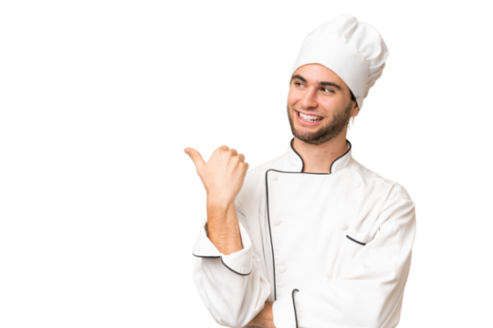 Young handsome chef man over isolated background pointing to the side to present a product