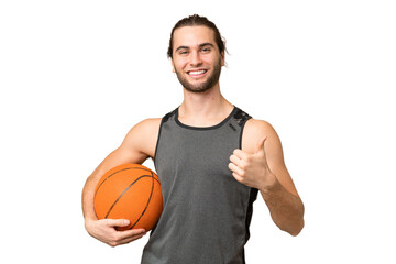 Obraz premium Young handsome man isolated on green chroma background playing basketball and with thumb up