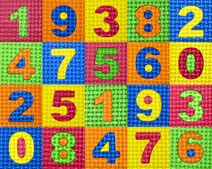 A pattern of numbers of different colors in multi-colored square cells. Arabic numerals close-up. Mathematical mosaic carpet