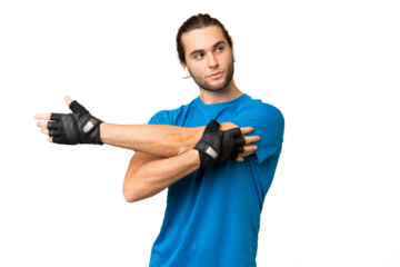 Young handsome man isolated on green chroma background stretching arm