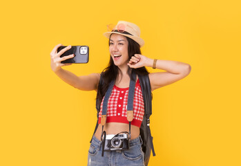 Young asian woman with retro camera, pasport  on yellow background or isolated in vacation with suitcase and passport.smiling cheerful woman hand using smartphone credit card.
