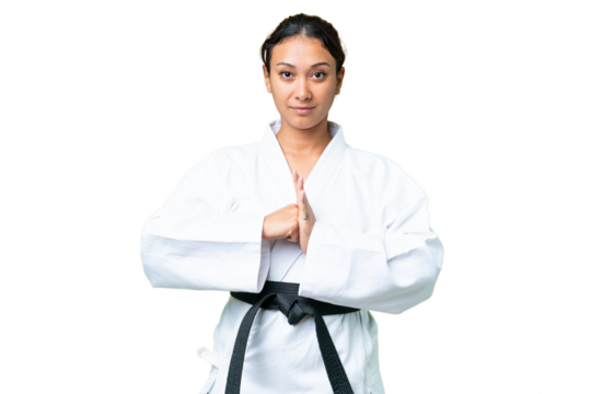 Young Uruguayan woman over isolated chroma key background doing karate and saluting - Powered by Adobe